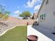 Large backyard featuring a concrete patio, artificial grass, desert rock landscaping, and view of the surrounding community at 3032 Hartley Cove Ave, North Las Vegas, NV 89081
