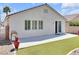 Well-maintained backyard with artificial grass, concrete patio, sliding glass door, and barbecue, perfect for entertaining at 3032 Hartley Cove Ave, North Las Vegas, NV 89081