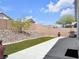 Landscaped backyard featuring artificial grass, desert rock, a large concrete patio, and barbecue area, great for outdoor entertaining at 3032 Hartley Cove Ave, North Las Vegas, NV 89081