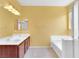 Well-lit bathroom featuring double sinks, a large mirror, and a bathtub at 3032 Hartley Cove Ave, North Las Vegas, NV 89081