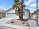 A well-kept single-story house with a two-car garage, desert landscaping, and sidewalks at 3032 Hartley Cove Ave, North Las Vegas, NV 89081