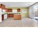 The bright kitchen features wood cabinets, an island, tile floors, and stainless steel appliances at 3032 Hartley Cove Ave, North Las Vegas, NV 89081
