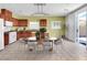 The bright kitchen features wood cabinets, an island, tile floors, and stainless steel appliances at 3032 Hartley Cove Ave, North Las Vegas, NV 89081