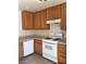 Bright kitchen with tile flooring featuring wooden cabinets and white appliances at 3123 Inlet Bay Ave, North Las Vegas, NV 89031