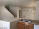 Kitchen area with a view of the staircase, featuring wood cabinets and white countertops at 3123 Inlet Bay Ave, North Las Vegas, NV 89031