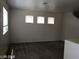 Neutral living room with carpet, three windows, and natural light at 3123 Inlet Bay Ave, North Las Vegas, NV 89031