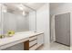 Bright bathroom with a long vanity, white cabinets, a large mirror, and a walk-in shower at 313 Firestone Dr, Las Vegas, NV 89145