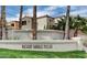 Exterior view of a Desert Shores Villa with palm trees and a stucco wall at 3151 Soaring Gulls Dr # 1092, Las Vegas, NV 89128