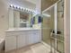 Bright bathroom featuring a double sink vanity with white cabinets and glass shower enclosure at 3263 Quail Song Dr, Laughlin, NV 89029