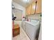 Bright laundry area features tile floors, washer, dryer, storage cabinet, and overhead cabinets at 3263 Quail Song Dr, Laughlin, NV 89029