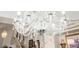 Close-up on a crystal chandelier, showing the staircase and art in the background at 3704 Blairmoor St, North Las Vegas, NV 89032