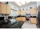 Bright kitchen with black countertops and wood cabinets with modern appliances at 3704 Blairmoor St, North Las Vegas, NV 89032