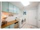Bright laundry room featuring modern washer and dryer, tiled floors, and plenty of storage at 3704 Blairmoor St, North Las Vegas, NV 89032