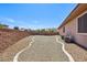 View of the low maintenance backyard that features rock landscaping and a stone perimeter at 3904 Redbreast Ln, North Las Vegas, NV 89084