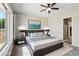 Staged bedroom with a ceiling fan, neutral walls, and a large window for natural light at 3904 Redbreast Ln, North Las Vegas, NV 89084