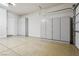 Large garage featuring epoxy flooring, built in white cabinets and access door to the house at 3904 Redbreast Ln, North Las Vegas, NV 89084