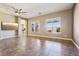 Open living room with tile flooring, two large windows and ceiling fan at 3904 Redbreast Ln, North Las Vegas, NV 89084