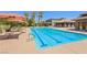 Community pool featuring lap lanes, sun umbrellas, tables, and lounge chairs, perfect for relaxation and recreation at 3904 Redbreast Ln, North Las Vegas, NV 89084