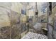 Tiled shower features stone pebble floor, built-in shelving, and modern fixtures at 3904 Redbreast Ln, North Las Vegas, NV 89084