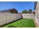 Backyard featuring manicured artificial grass and block wall fencing at 4052 Compass Rose Way, Las Vegas, NV 89108