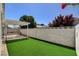 An enclosed backyard features synthetic grass, a covered patio, and privacy provided by a block wall at 4052 Compass Rose Way, Las Vegas, NV 89108