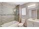 Bathroom featuring a glass-enclosed shower and tub combination with neutral tile at 4052 Compass Rose Way, Las Vegas, NV 89108