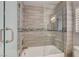 Modern bathroom featuring a tub with a glass door, stylish wall tiles, and updated fixtures at 4052 Compass Rose Way, Las Vegas, NV 89108