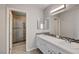 Bathroom featuring a dual sink vanity with white cabinets and a large mirror at 4052 Compass Rose Way, Las Vegas, NV 89108