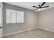 Bedroom featuring wood-look tile, a ceiling fan, and window with blinds at 4052 Compass Rose Way, Las Vegas, NV 89108