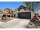 A well-maintained home features a dark garage door, desert landscaping, and a tile roof at 4052 Compass Rose Way, Las Vegas, NV 89108