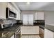 Bright kitchen features white cabinets, stainless appliances, mosaic backsplash, and countertops at 4052 Compass Rose Way, Las Vegas, NV 89108