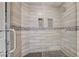 Close-up of tiled shower with pebble-look shower floor and glass door at 4052 Compass Rose Way, Las Vegas, NV 89108