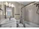 Bright bathroom with a single sink vanity, updated shower-tub combo, and decorative tile at 460 Pear Lake St, Las Vegas, NV 89138