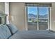 A bedroom with a sliding glass door that provides access to a balcony overlooking a view of the city at 460 Pear Lake St, Las Vegas, NV 89138