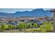 Beautiful street view of modern homes with lush green landscaping, framed by mountain views at 460 Pear Lake St, Las Vegas, NV 89138