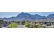 Scenic street view of modern homes, lush trees, and majestic mountains in the background at 460 Pear Lake St, Las Vegas, NV 89138