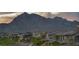 Charming street view of a new home community with mountain views in the background at dusk at 460 Pear Lake St, Las Vegas, NV 89138