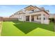 Backyard features a manicured lawn, outdoor kitchen, and covered patio at 484 Windstone Crest Ave, Las Vegas, NV 89138