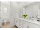 Bright bathroom featuring double sinks with white cabinets and a separate toilet and shower room at 484 Windstone Crest Ave, Las Vegas, NV 89138