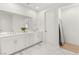 Bright bathroom featuring white marble-style tile floors, double vanity, and modern fixtures at 484 Windstone Crest Ave, Las Vegas, NV 89138