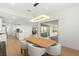 Open dining area with a wood table, modern light fixture, seating for six, and seamless access to the kitchen at 484 Windstone Crest Ave, Las Vegas, NV 89138