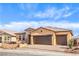 Single-story home with three-car garage, stone accents, neutral stucco and a well-maintained desert landscaped front yard at 522 Copper Falcon Ave, Henderson, NV 89011