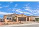 Attractive single-story home with tan stucco, stone accents, a three-car garage and nicely landscaped front yard at 522 Copper Falcon Ave, Henderson, NV 89011