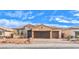 Charming single-story home featuring a three-car garage, stone accents, and a well-maintained front yard under a bright sky at 522 Copper Falcon Ave, Henderson, NV 89011