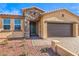Close-up of a home's facade showing the stone accents, olive front door, and three-car garage at 522 Copper Falcon Ave, Henderson, NV 89011