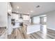 Open-concept kitchen with granite countertops, stainless steel appliances, white cabinets, and wood flooring at 522 Copper Falcon Ave, Henderson, NV 89011