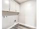 This laundry room offers modern gray wood flooring and white cabinets for ample storage space at 522 Copper Falcon Ave, Henderson, NV 89011
