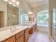 Bathroom featuring double sinks, wood cabinetry, and separate shower and soaking tub at 5260 Acqua Ln, Pahrump, NV 89061
