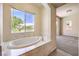 Bathroom showcasing a soaking tub under a large window, offering serene views at 5260 Acqua Ln, Pahrump, NV 89061