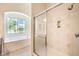 Bathroom featuring a glass-enclosed shower, soaking tub, and bright window at 5260 Acqua Ln, Pahrump, NV 89061